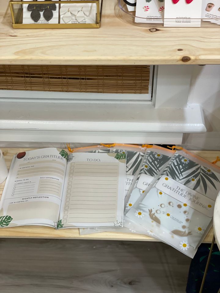 Copies of The Divine Gratitude Journal on a display table in a local shop.